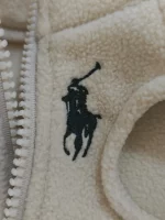 Close-up of cream fleece cat vest texture and zipper detail